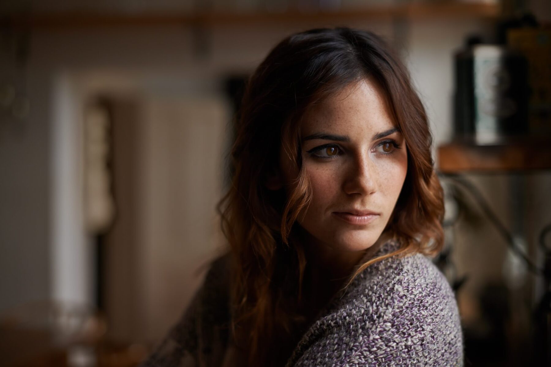 Head and shoulders shot of a beautiful brunette woman alone in a house