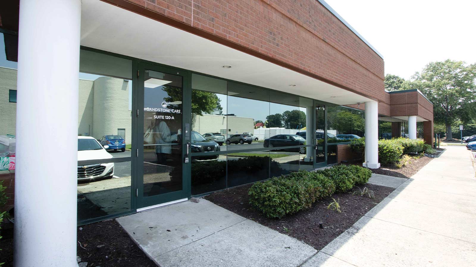 there is a car parked in front of a building with a glass door