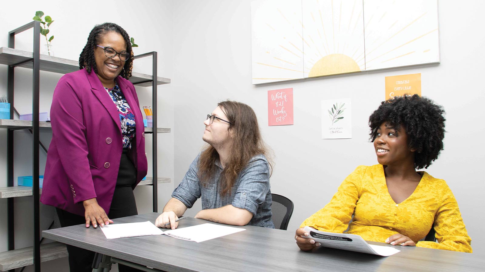 two young adults and a teacher in a classroom setting