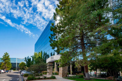 Sandstone Care's Denver Mental Health Centers building with surrounded with greenery under a clear blue sky.