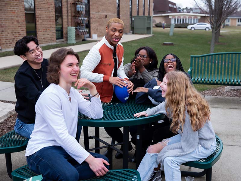 several people sitting at a table with a cup of coffee