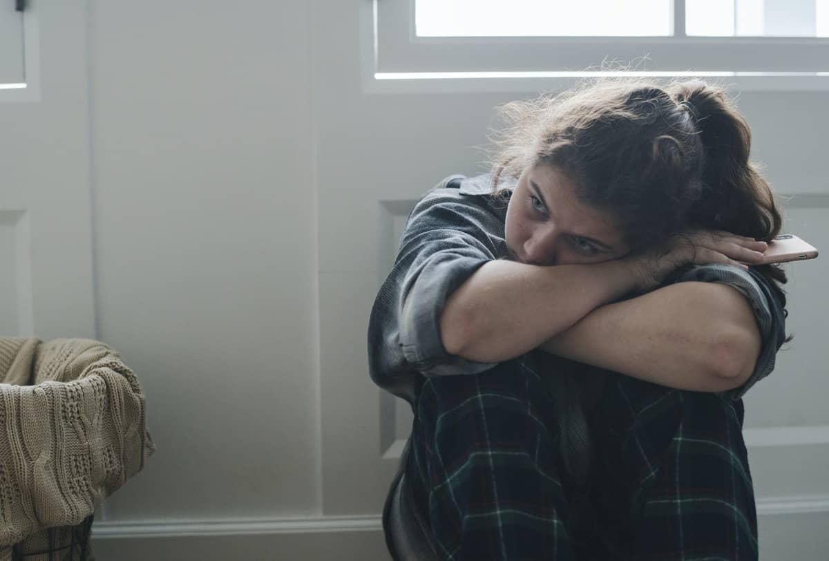 Girl sitting alone and sad in her room