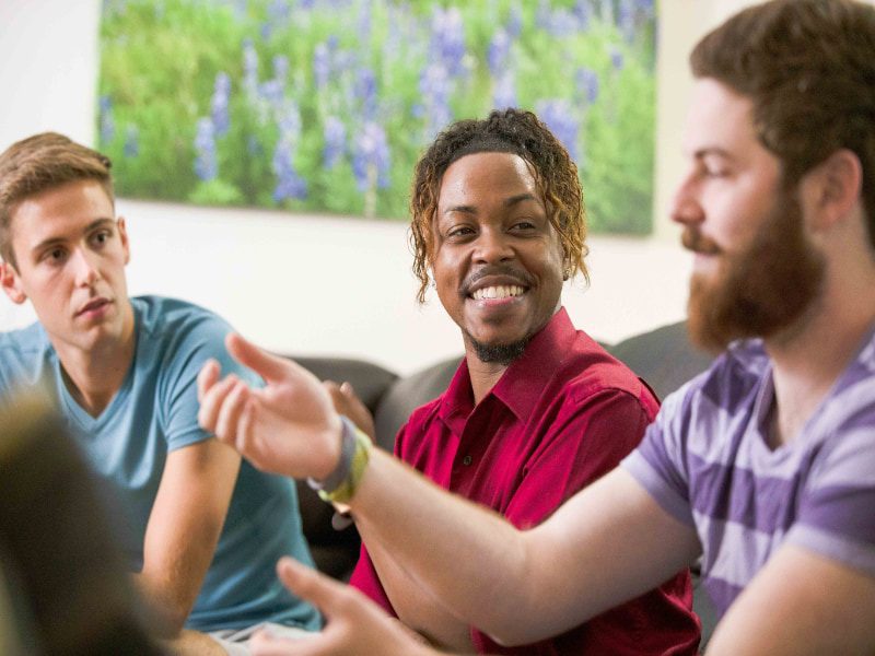 Three young men talking