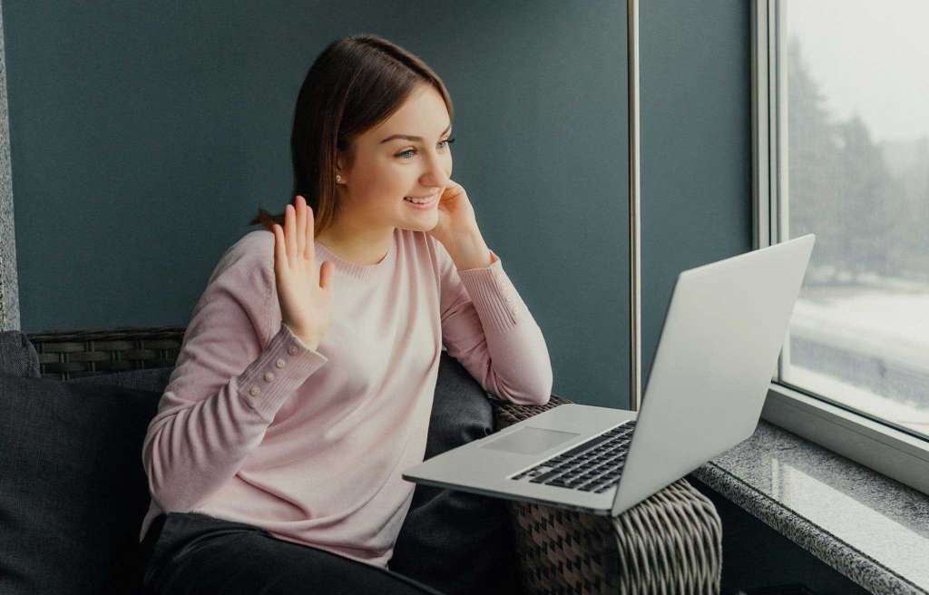 young adult on couch using computer