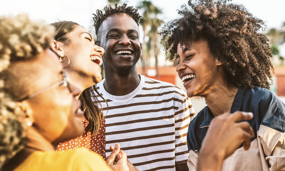 Young happy people laughing together - Multiracial friends group having fun on city street - Diverse culture students portrait celebrating outside - Friendship, community, youth, university concept