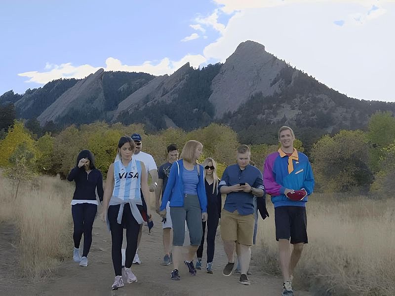 group of people on a hiking trail with mountains in the background